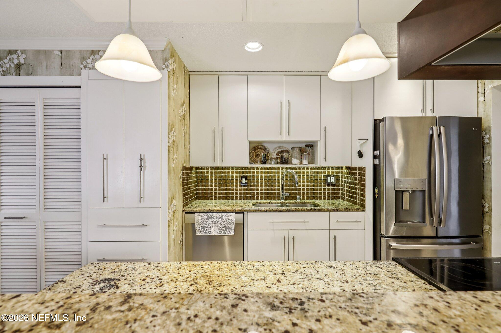 11654 Lake Ride Drive Jacksonville, FL 32223 - Photo 15 of 36 a kitchen with kitchen island a sink stainless steel appliances and cabinets