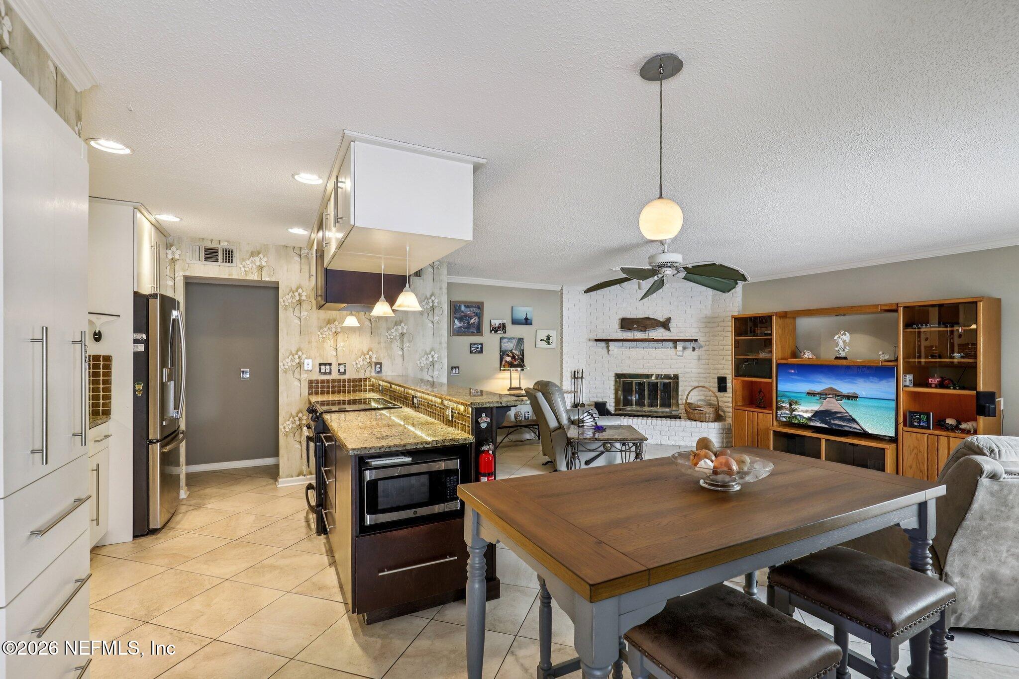 11654 Lake Ride Drive Jacksonville, FL 32223 - Photo 17 of 36 a kitchen with stainless steel appliances granite countertop a stove a refrigerator a oven a sink with a dining table and chairs