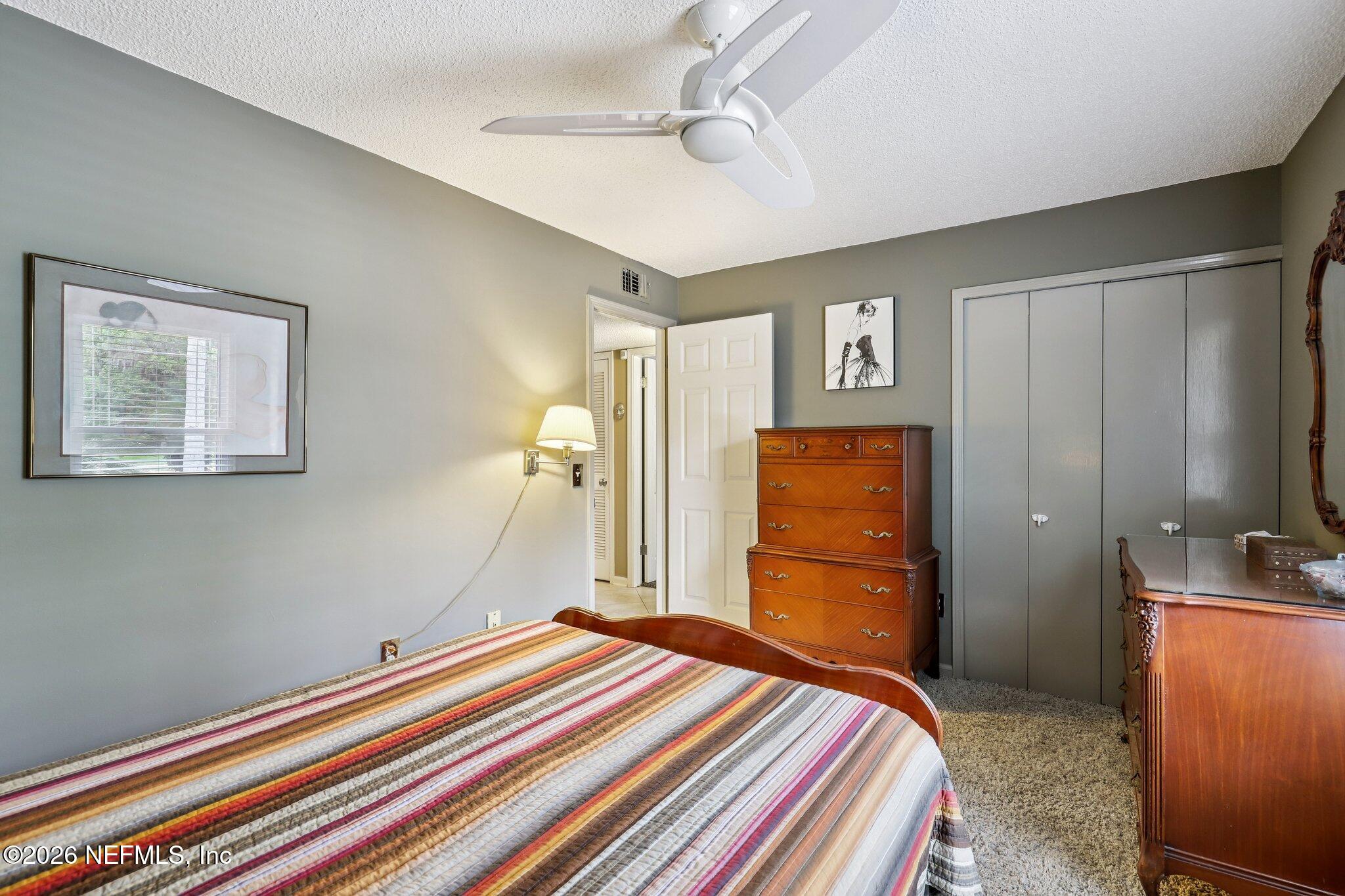 11654 Lake Ride Drive Jacksonville, FL 32223 - Photo 25 of 36 a bedroom with a bed and a chandelier