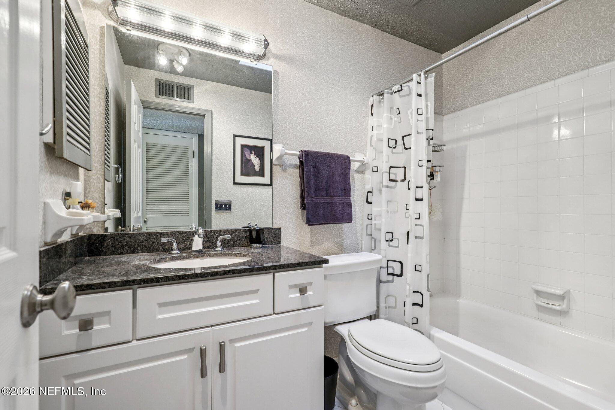 11654 Lake Ride Drive Jacksonville, FL 32223 - Photo 28 of 36 a bathroom with a granite countertop sink toilet mirror and shower