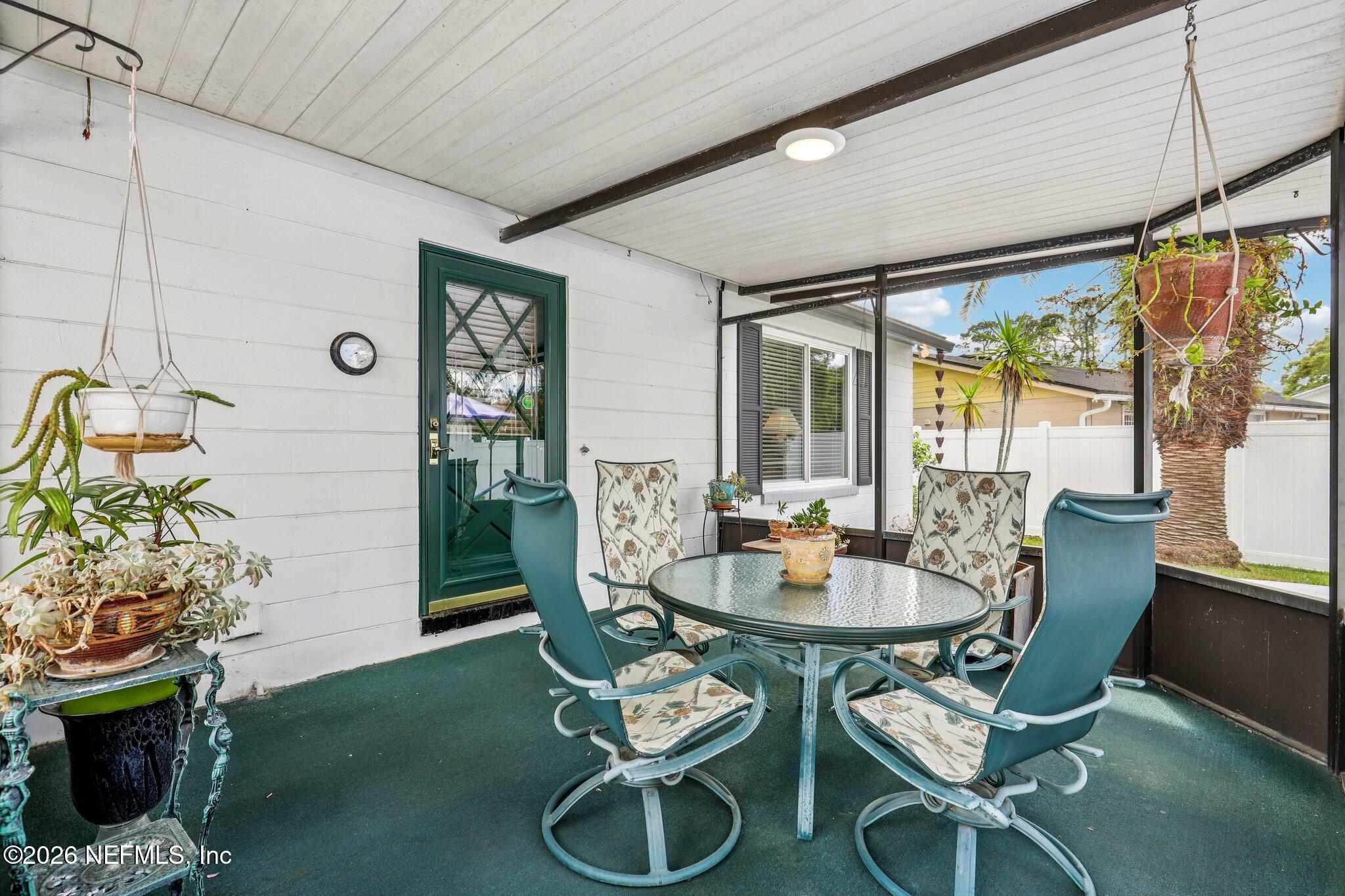 11654 Lake Ride Drive Jacksonville, FL 32223 - Photo 30 of 36 a dining room with furniture a rug a potted plant and a chandelier