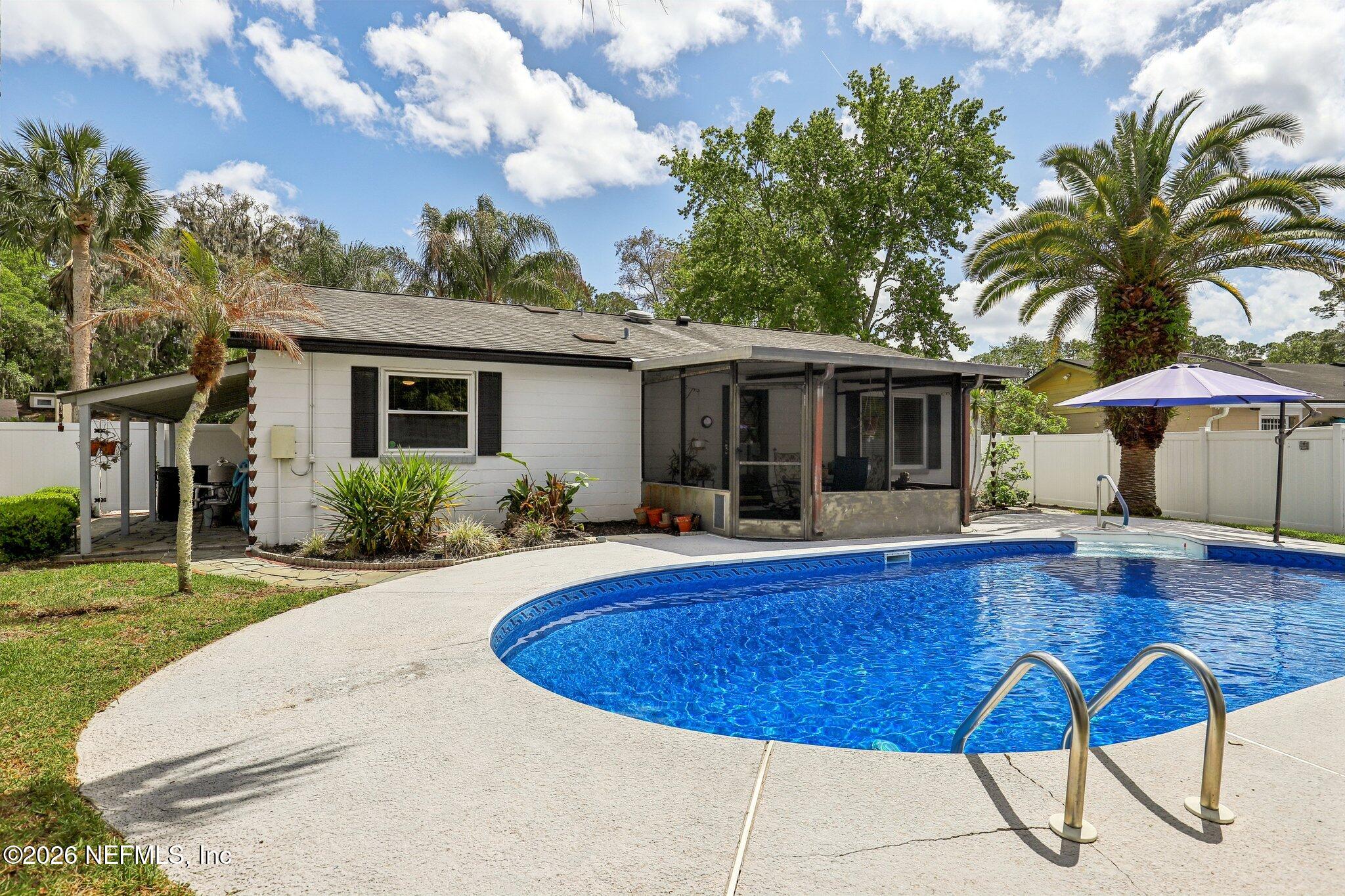 11654 Lake Ride Drive Jacksonville, FL 32223 - Photo 34 of 36 a view of house with swimming pool outdoor seating and covered with trees