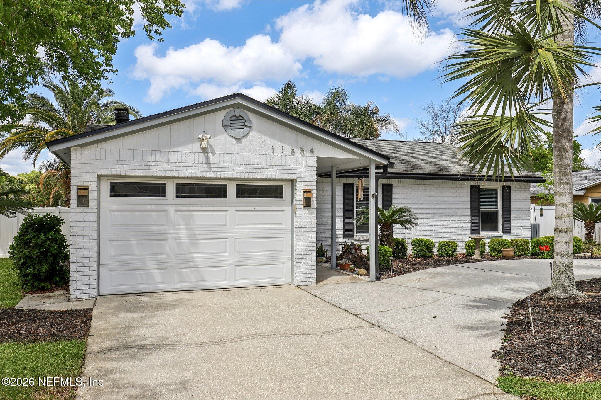 11654 Lake Ride Drive Jacksonville, FL 32223 - Photo 4 of 36 a front view of a house with a yard and garage