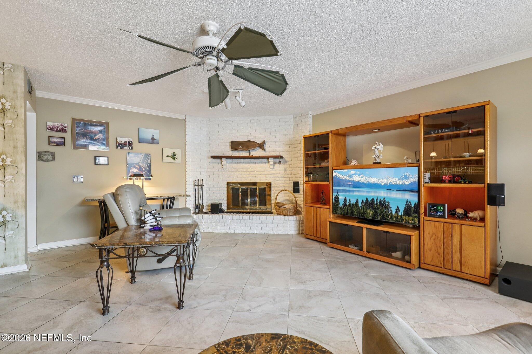 11654 Lake Ride Drive Jacksonville, FL 32223 - Photo 8 of 36 a living room with furniture a fireplace and a flat screen tv