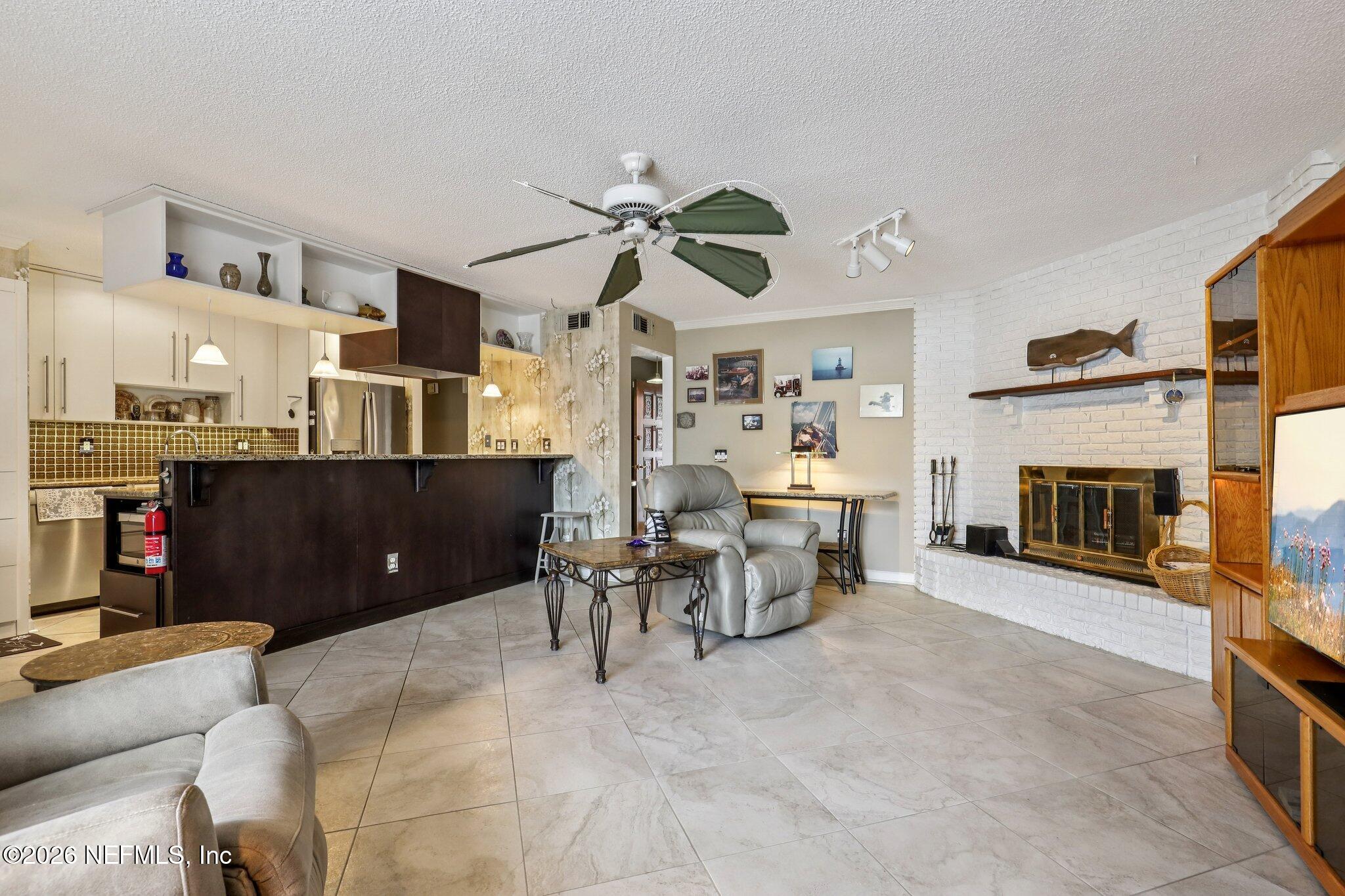 11654 Lake Ride Drive Jacksonville, FL 32223 - Photo 9 of 36 a living room with furniture a fireplace and a flat screen tv