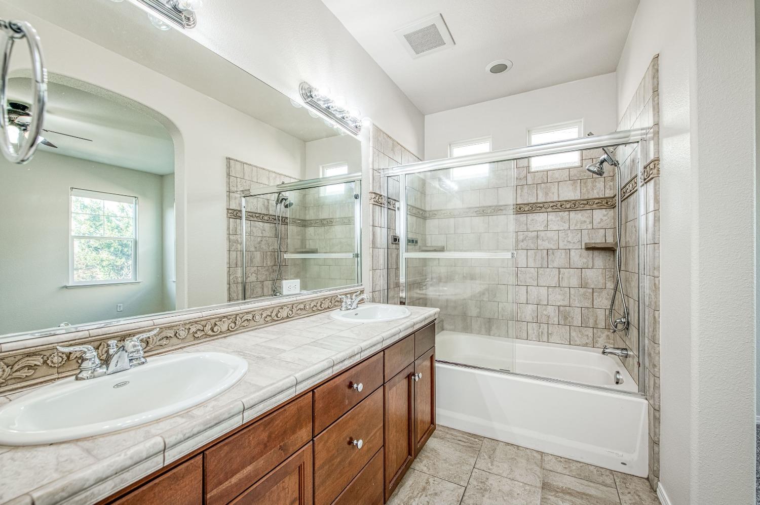 3991 Harlan Ranch Boulevard Clovis, CA 93619 - Photo 15 of 21 a bathroom with a granite countertop sink mirror bathtub and shower