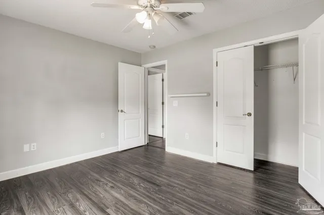 an empty room with wooden floor and closet area