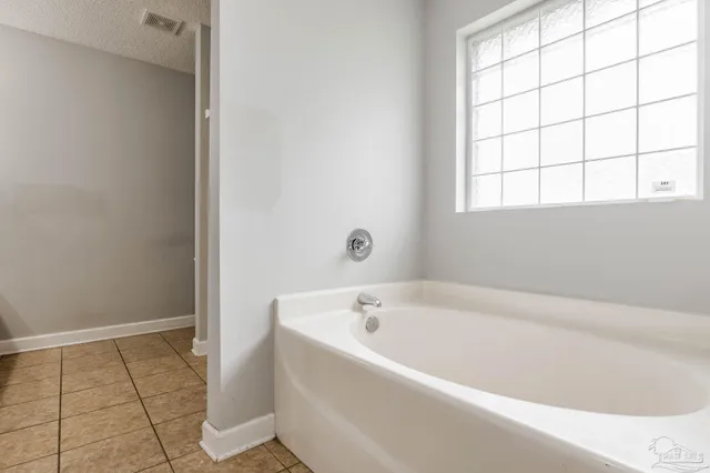 a white bath tub sitting in a bathroom next to a window