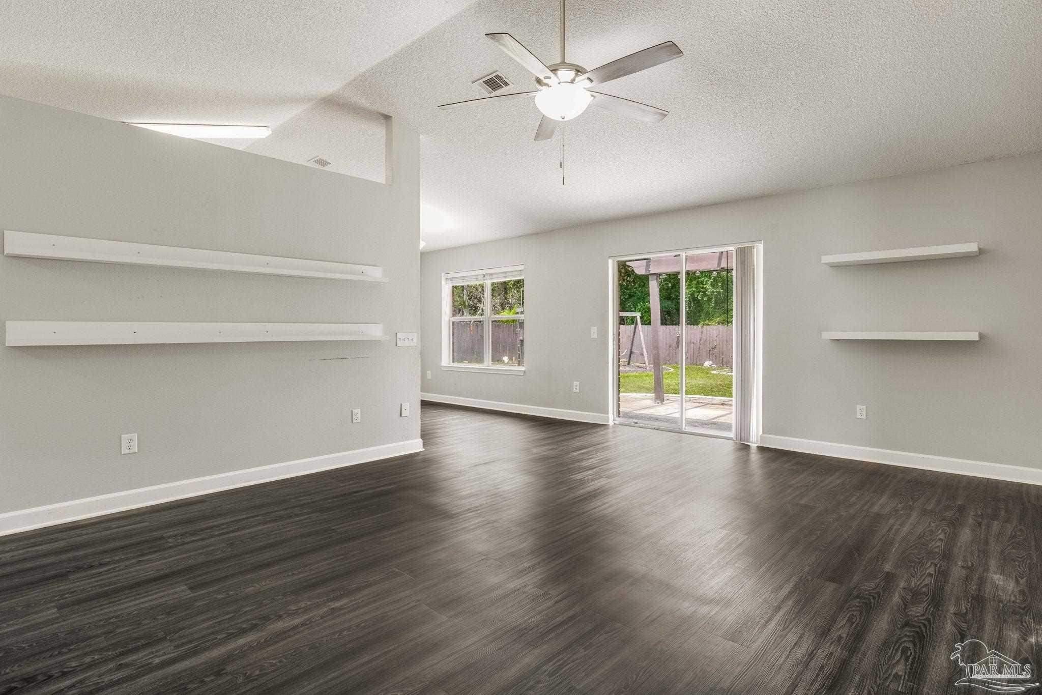 1068 Joaquin Road Pensacola, FL 32506 - Photo 6 of 23 a view of an empty room with a window and wooden floor