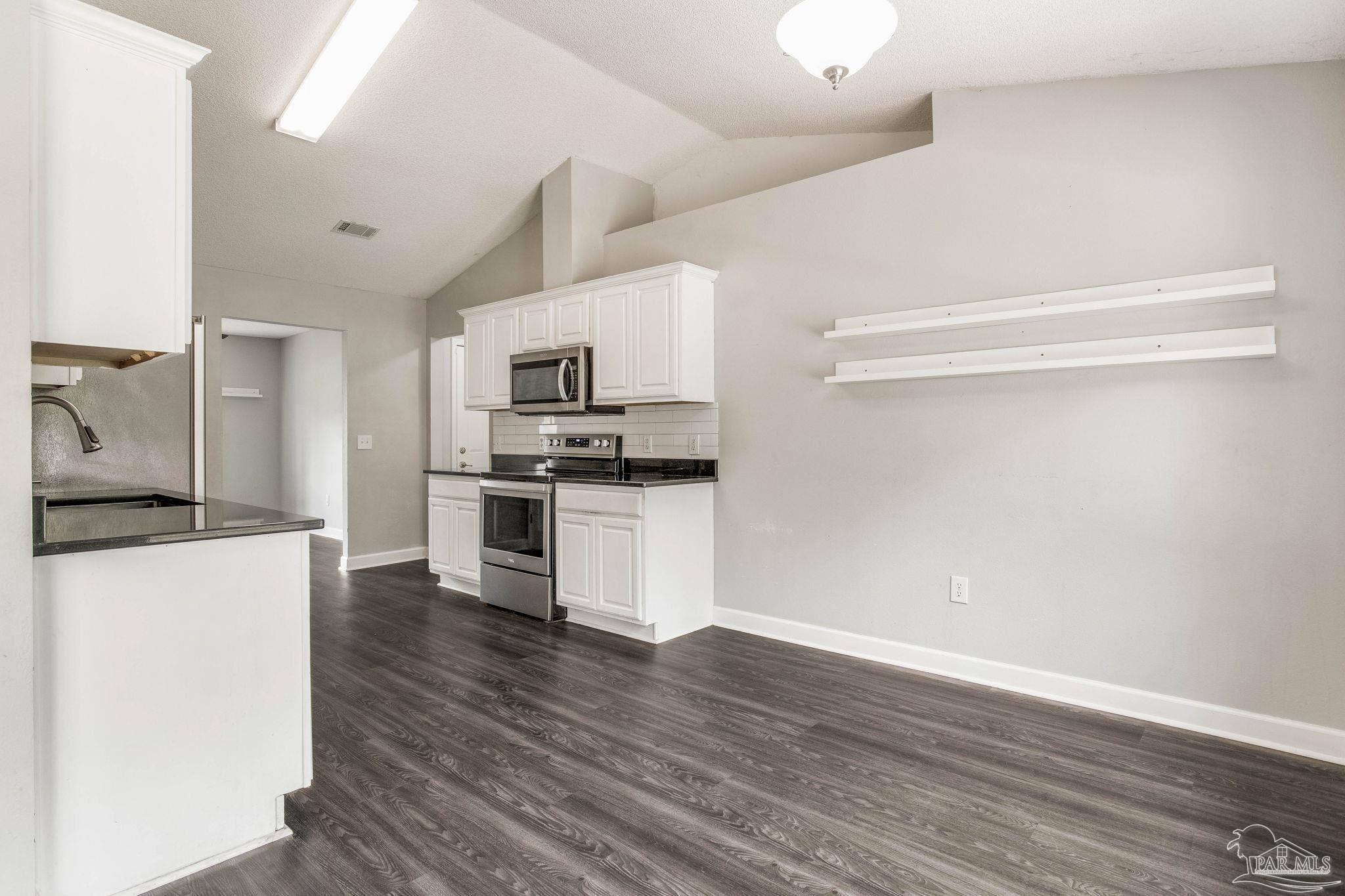 1068 Joaquin Road Pensacola, FL 32506 - Photo 8 of 23 a kitchen with granite countertop a refrigerator and a stove