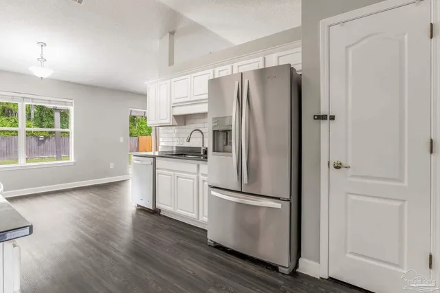 a kitchen with stainless steel appliances a refrigerator sink and cabinets