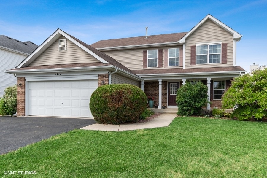 1417 Roth Drive Joliet, IL 60431 - Photo 1 of 18 a view of a yard in front of a house with plants and large tree
