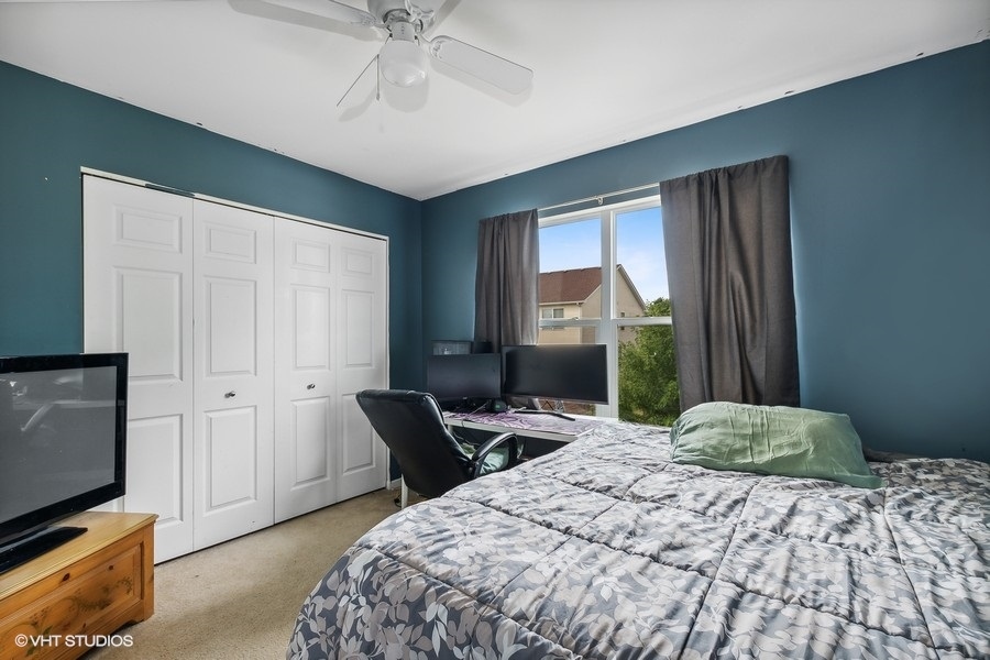 1417 Roth Drive Joliet, IL 60431 - Photo 13 of 18 a bedroom with a bed and a flat tv screen