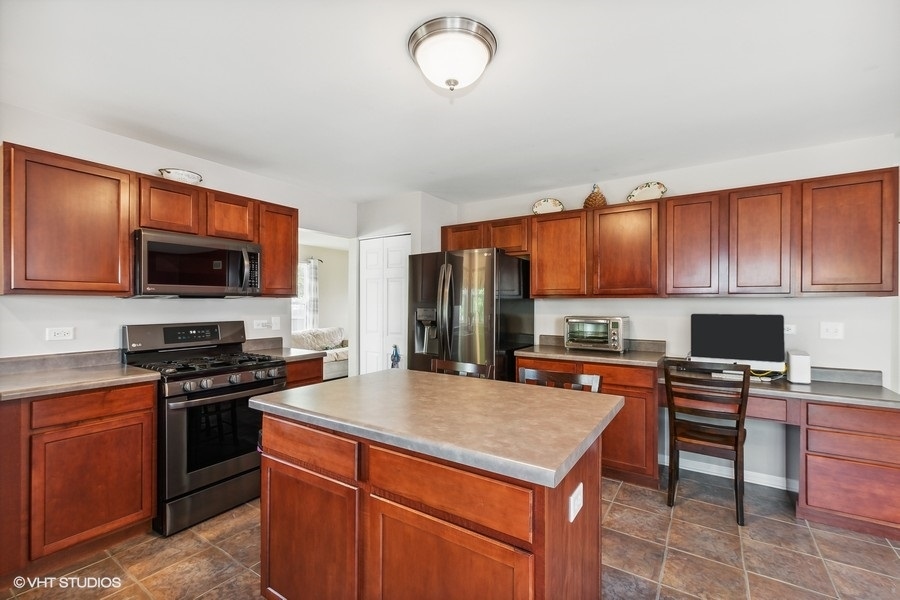 1417 Roth Drive Joliet, IL 60431 - Photo 5 of 18 a kitchen with stainless steel appliances a stove sink microwave and refrigerator