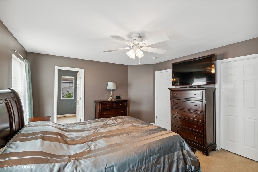 1417 Roth Drive Joliet, IL 60431 - Photo 10 of 18 a bedroom with a bed and a flat screen tv