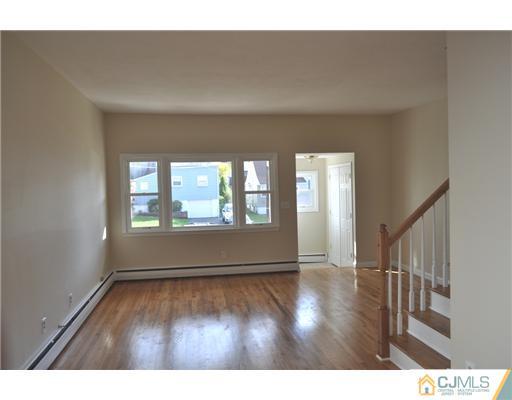 51 Farmingdale Road Fords, NJ 08863 - Photo 3 of 6 a view of an empty room with wooden floor and a window