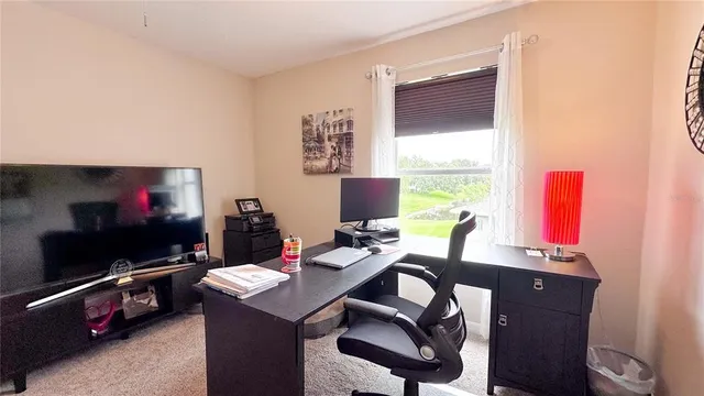 a view of a workspace with furniture and a flat screen tv