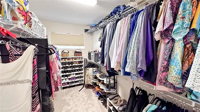 a view of walk in closet with clothes