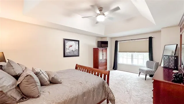 a bedroom with a large bed a flat screen tv and couches
