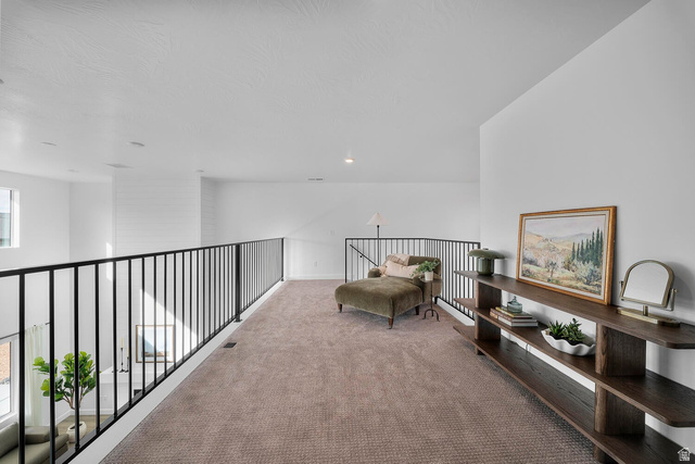 382 North Rhyolite Drive, Unit 111 Hurricane, UT 84737 - Photo 20 of 37 Spacious upper-level landing featuring a dark metal railing, light-colored carpet, recessed lighting, and a built-in multi-tiered dark wood console