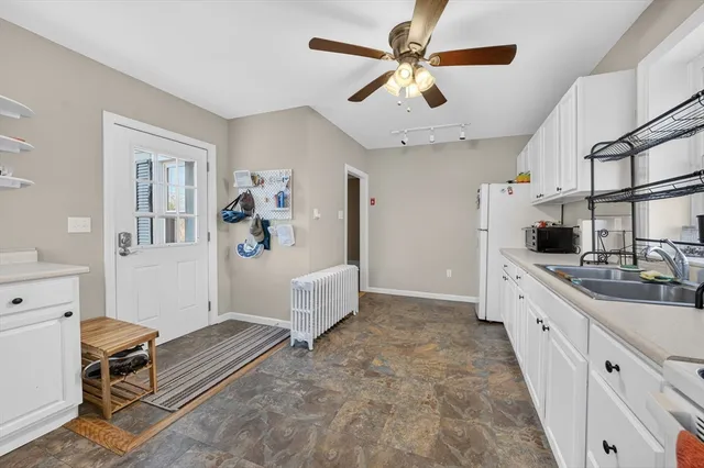 a kitchen with kitchen island white cabinets and white appliances