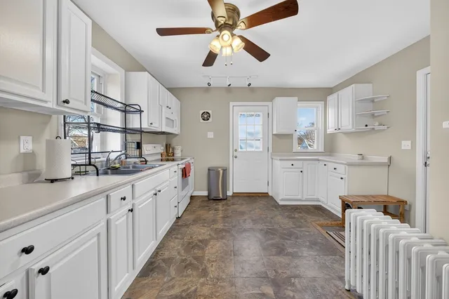 a view of a livingroom with wooden floor and a ceiling fan