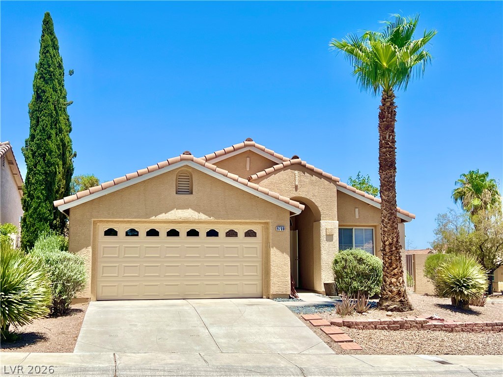 9708 Ridge Creek Place Las Vegas, NV 89134 - Photo 2 of 43 A well-maintained desert landscape frames this welcoming single-story residence with a two-car garage. Palm tree just trimmed.