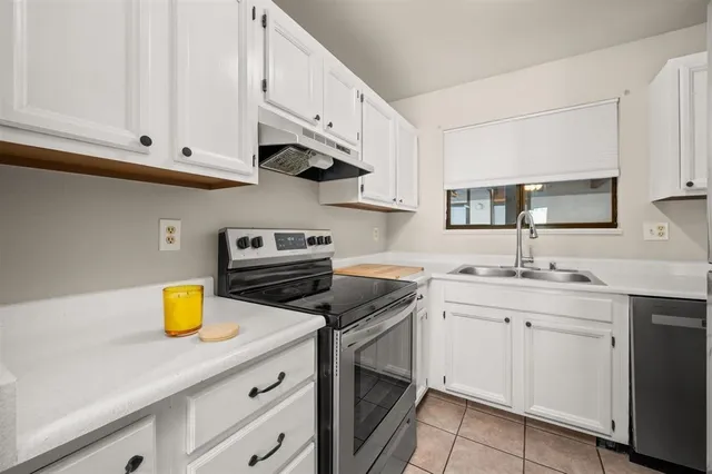 a kitchen with cabinets stainless steel appliances a sink and a counter space