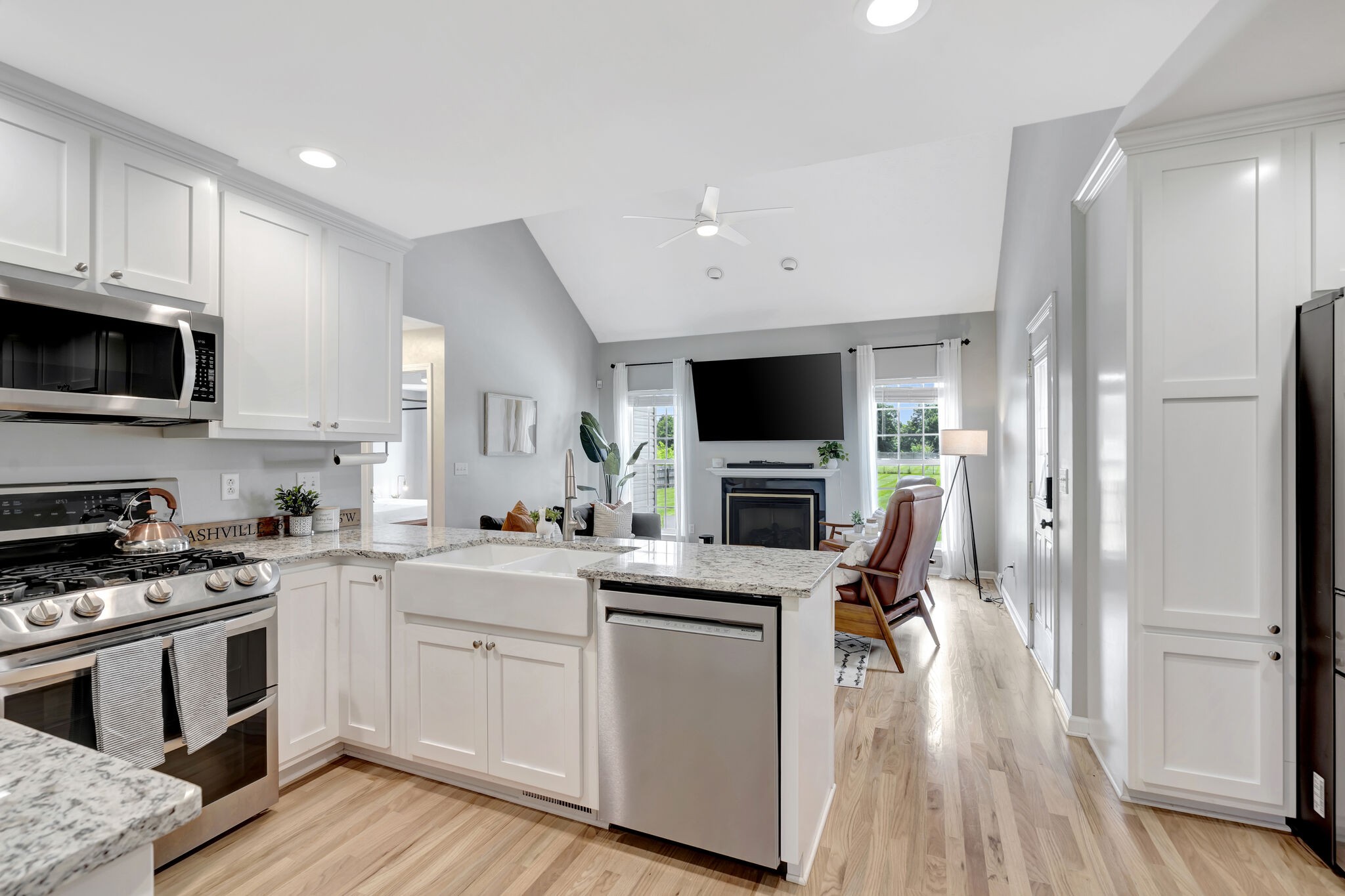 1212 Old Eastside Road Burns, TN 37029 - Photo 8 of 39 a kitchen with white cabinets stainless steel appliances and wooden floor