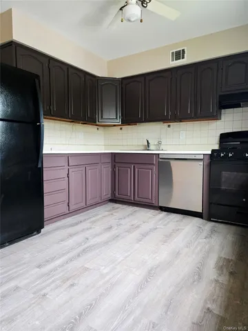 a kitchen with granite countertop a stove a refrigerator and a sink