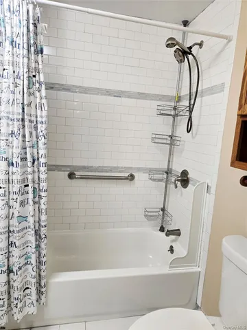 a bathroom with a shower and a white bath tub