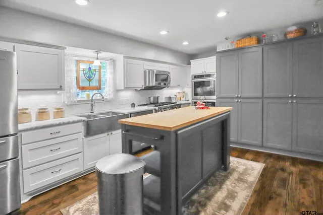 a kitchen with stainless steel appliances granite countertop a sink stove and cabinets
