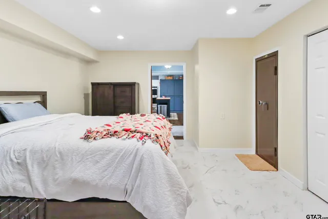 a spacious bedroom with a bed and a chandelier
