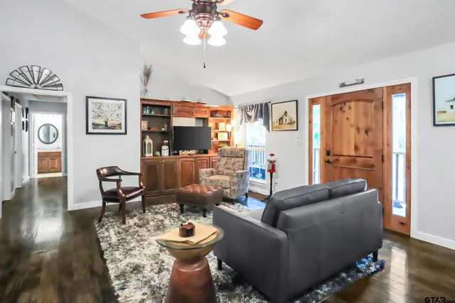 a living room with stainless steel appliances kitchen island granite countertop furniture and a chandelier