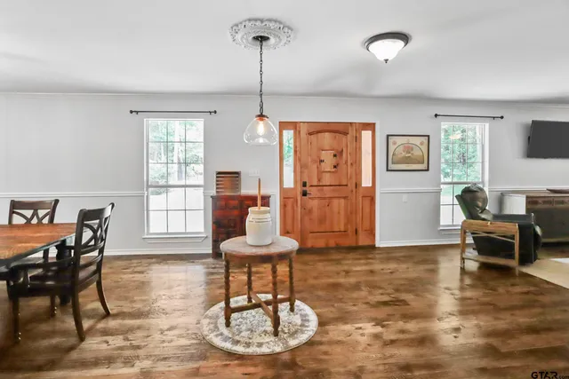 a living room with furniture a dining table and a window