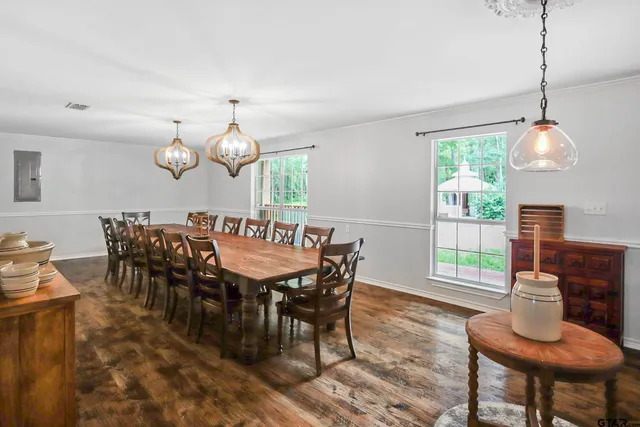 a dining room filled chandelier and wooden floor