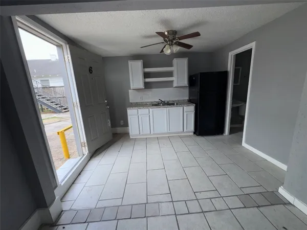 a view of a kitchen with a sink and a refrigerator