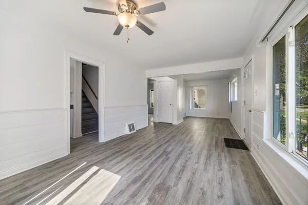 a view of a room with wooden floor staircase and a kitchen