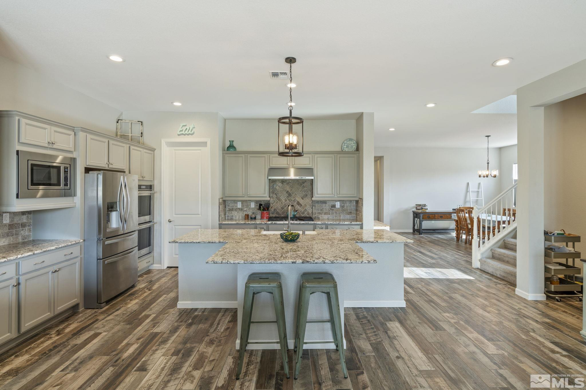 2305 Buttermere Drive Reno, NV 89521 - Photo 4 of 39 a large kitchen with kitchen island a dining table chairs stainless steel appliances and cabinets