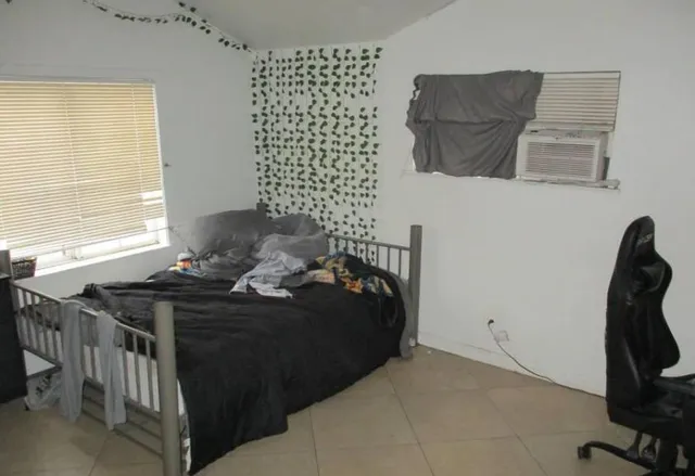 a bedroom with a bed and a window