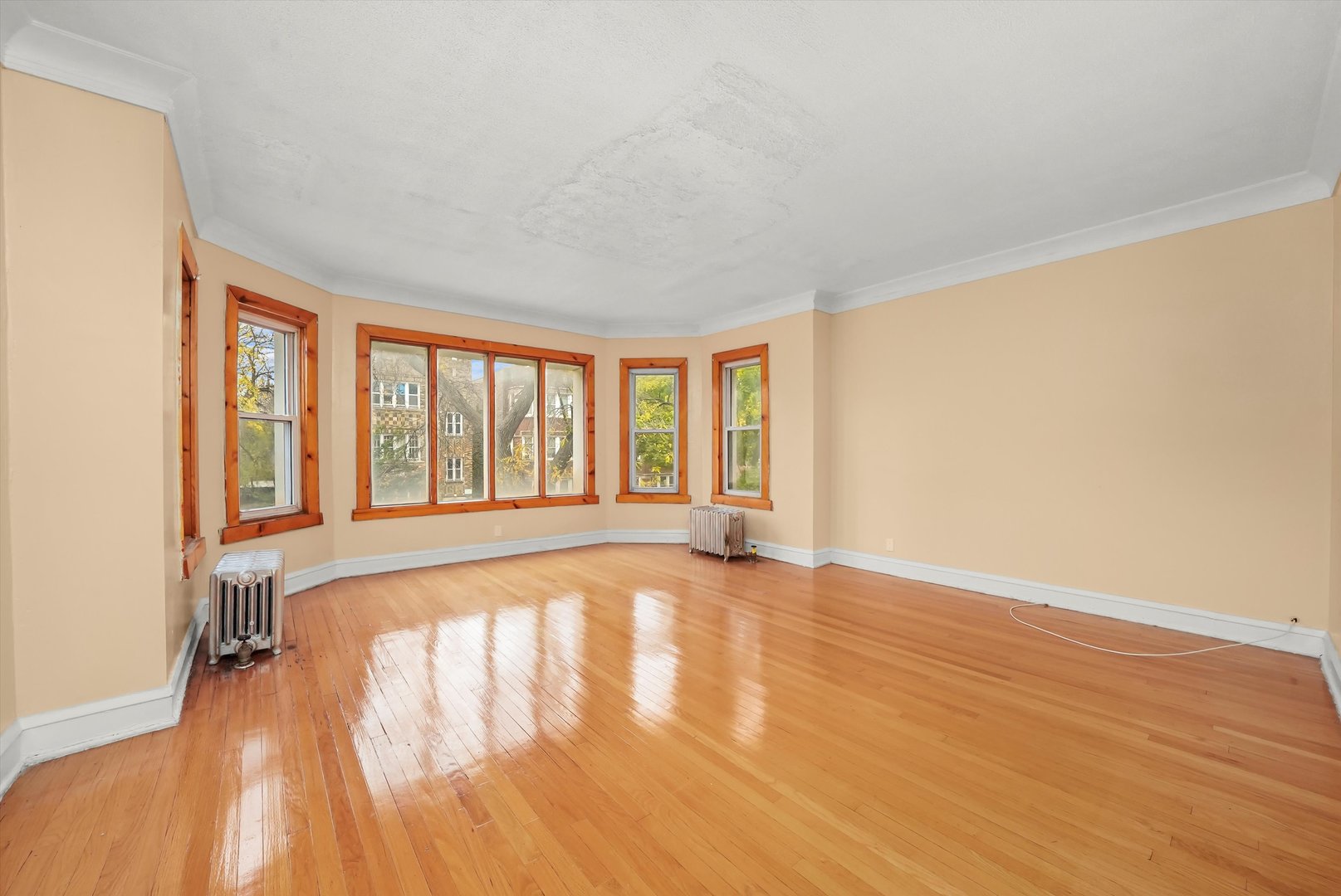 7825 South Phillips Avenue Chicago, IL 60649 - Photo 18 of 55 a view of an empty room with wooden floor and a window