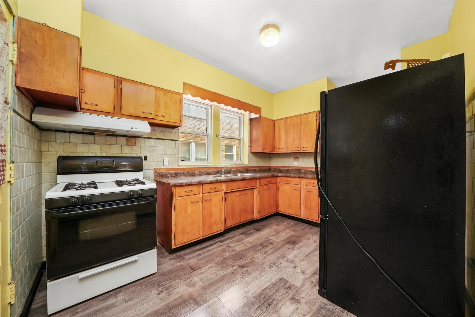 7825 South Phillips Avenue Chicago, IL 60649 - Photo 23 of 55 a kitchen with a stove a refrigerator and a sink