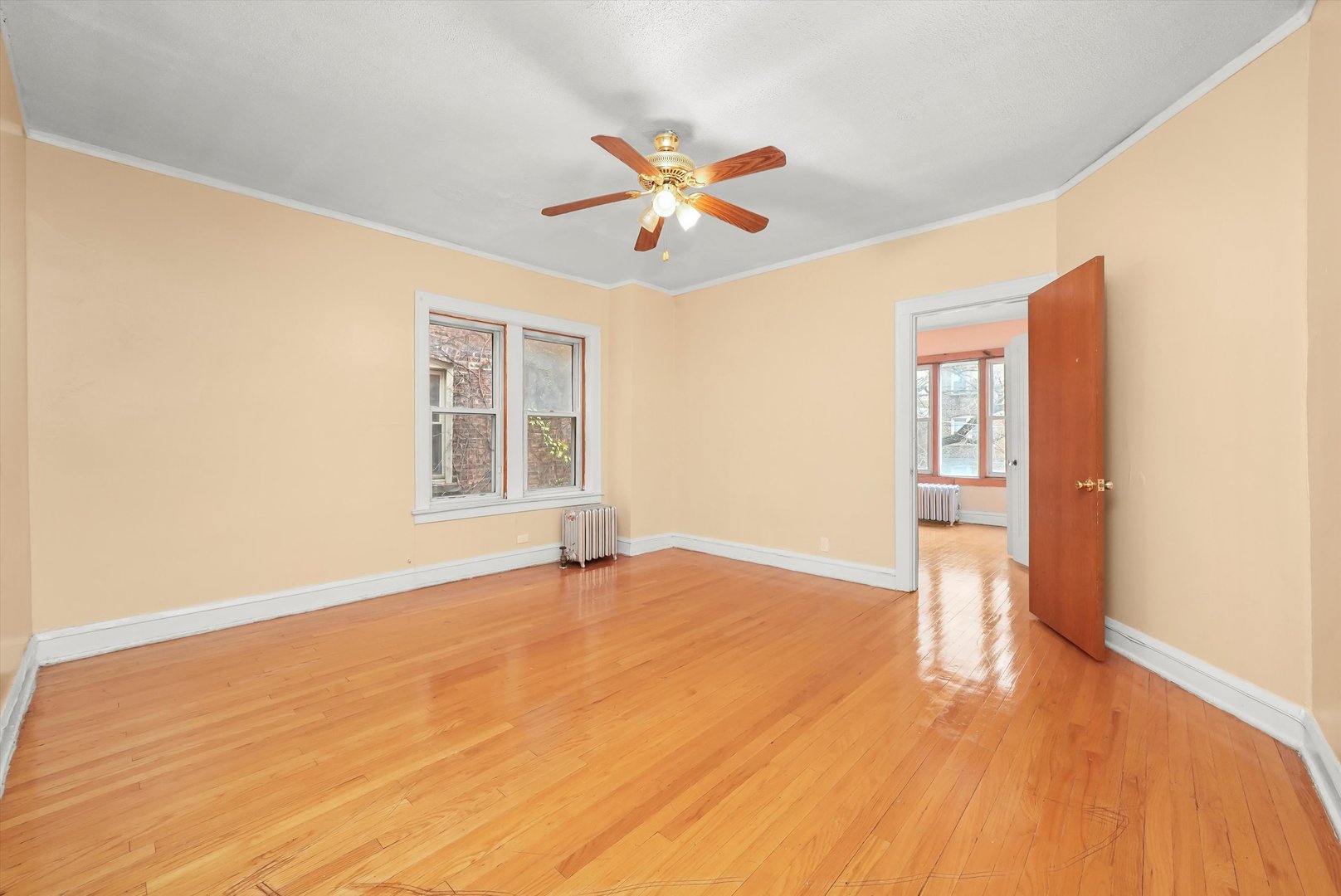 7825 South Phillips Avenue Chicago, IL 60649 - Photo 29 of 55 a view of an empty room with wooden floor and a window
