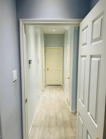 a view of a hallway with wooden floor and closet area