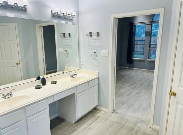 a bathroom with double sink and a mirror