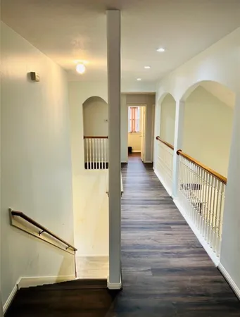 a view of a hallway with wooden floor