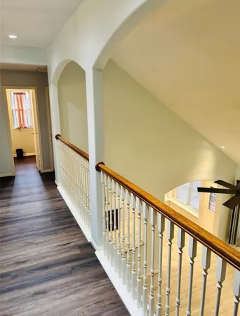 a view of a hallway with wooden floor and staircase