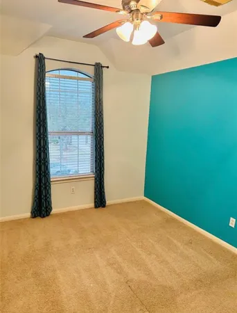 a view of a big room with windows and chandelier fan