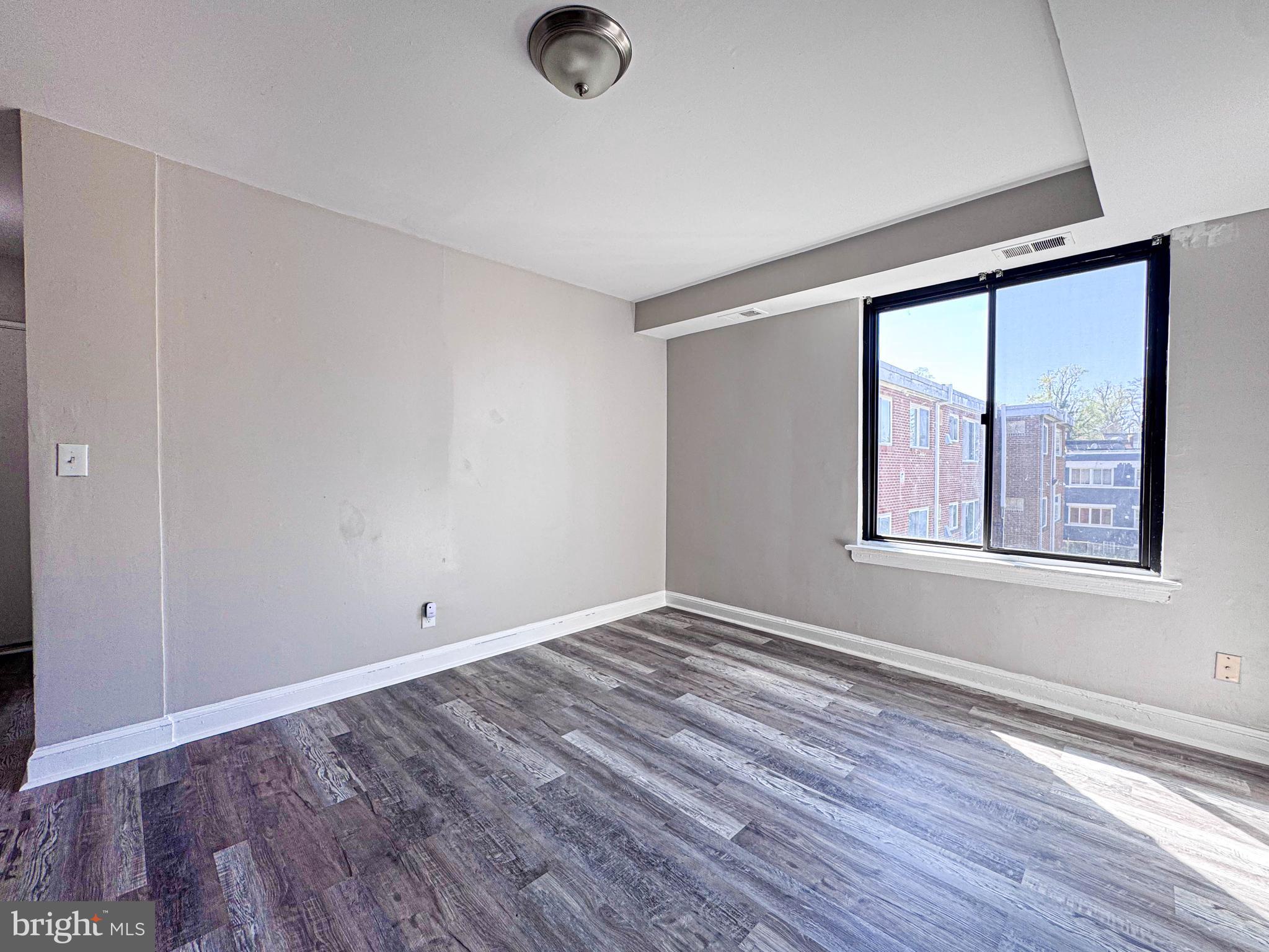 4630 Hillside Road Southeast, Unit 3 & 4 Washington, DC 20019 - Photo 8 of 23 an empty room with wooden floor and windows