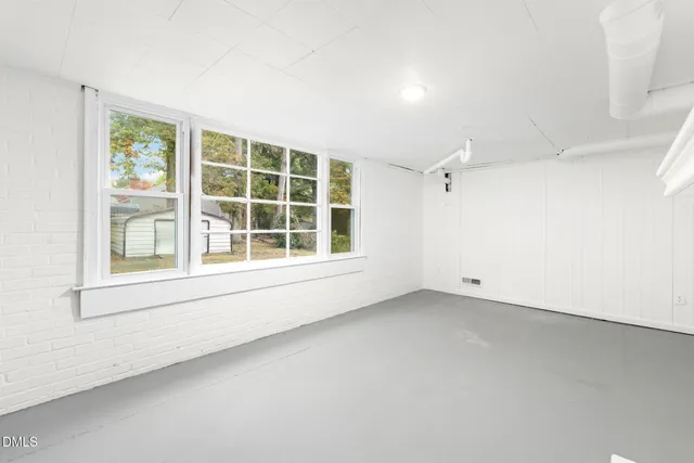 an empty room with a window and a ceiling fan